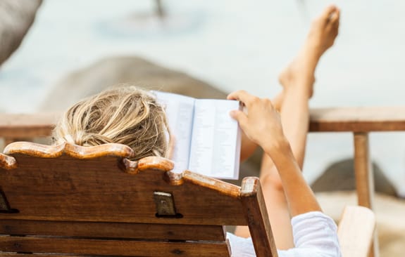 Woman resting in chair, reading a book