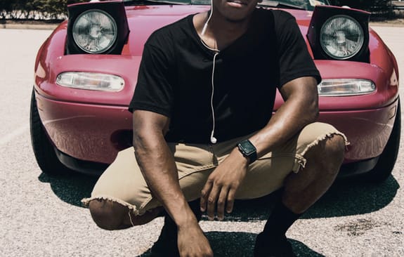 young male infront of vehicle