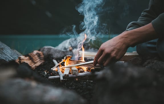 Male lighting a campfire