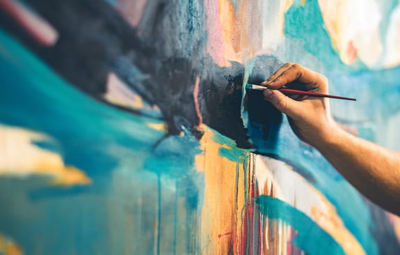 Hands of young painter working on his art inside his studio