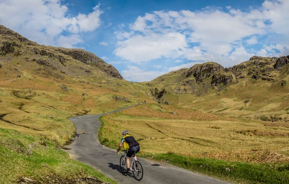 Cyclist climbing a hill looking to the horizon