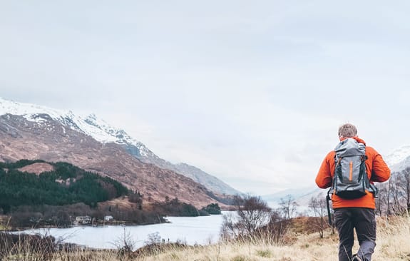 Man hiking towards snowy mountains