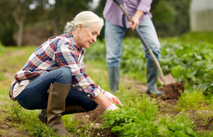 Woman with gardening gloves and boots in the garden