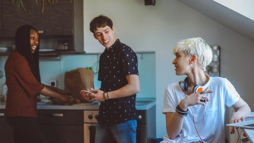 3 students talking in the shared kitchen