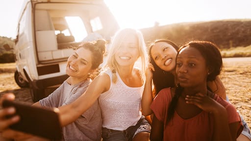 Young friends traveling along the coast in a campervan