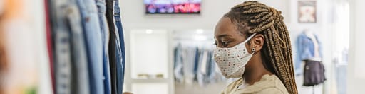 Shopper wearing mask looking at clothes