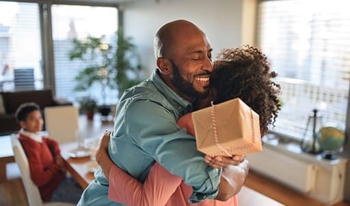 Man and women hugging with a rewards box in his hands from his Private Bank