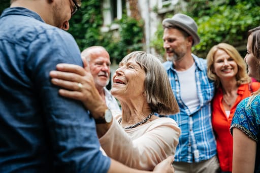 Elderly woman embracing young man