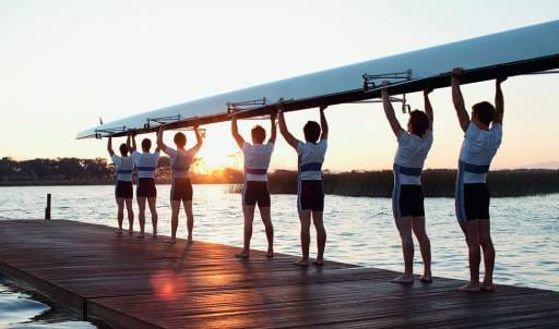 A rowing team loads their charity-backed boat into the water