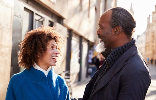 A man and woman talk while standing in a mews