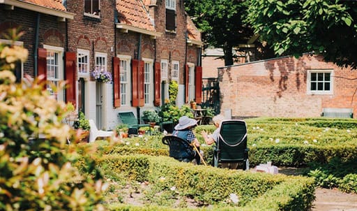 two elderly females sitting in garden chatting