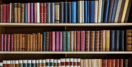 Hundreds of colourful books lined up on a library shelf