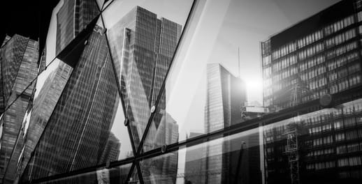 Looking at the reflection of corporate buildings in the windows of a glassed office