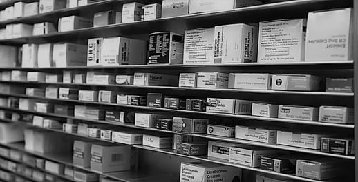 Medical drug boxes stacked on pharmacy shelves