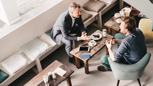 Image of two men conducting a business meeting over coffee