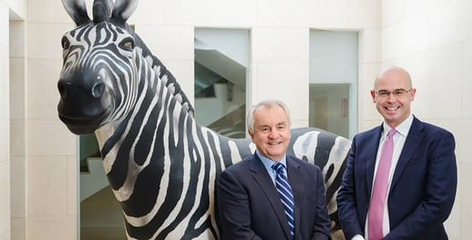 Michael Cullen and Derek Byrne standing infront of a Zebra