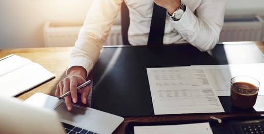 Real-time trading: businessman looking at documents at his desk