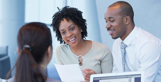 Couple talking over a table to a financial adviser