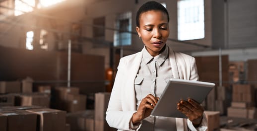 Factory manager using a digital tablet in a warehouse