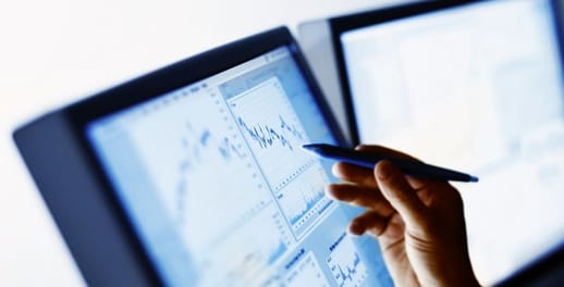 A trader points to a chart on a screen