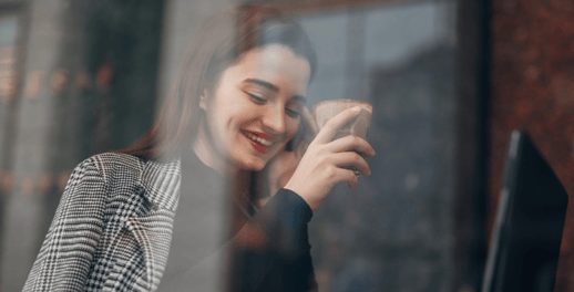 woman smiling and drinking coffee