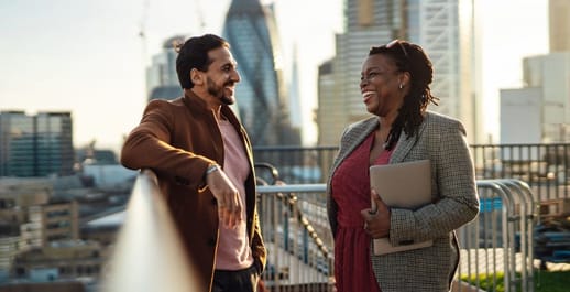 Business man and women on a balcony laughing 