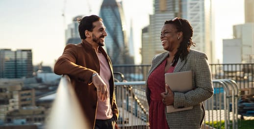 Business man and women on a balcony laughing 