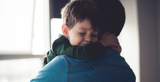 Young boy hugging his father