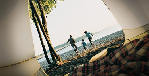 Family running from tent onto beach