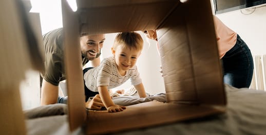 baby crawling through a cardboard box