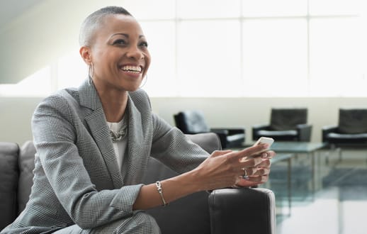 female smiling in a chair with mobile