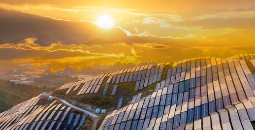 Sun rising over a hillside covered in solar panels