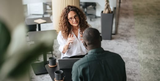 Adviser and client chatting at a small coffee table