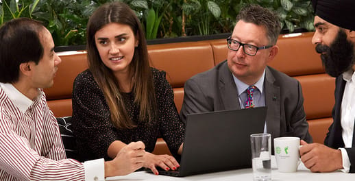 Team members chatting through plans at a coffee table