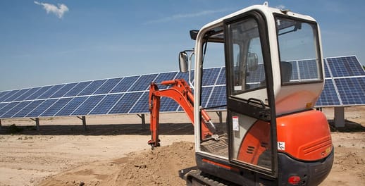 Digger next to solar panels