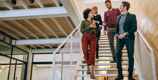 Office workers walking down stairs and chatting together