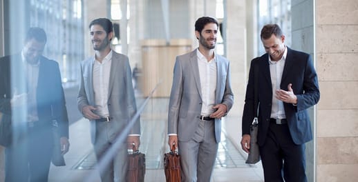 Two business men walking with their reflection showing to the side of them