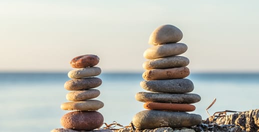 Small pebbles from the beach stacked upon one another to form two pebble towers