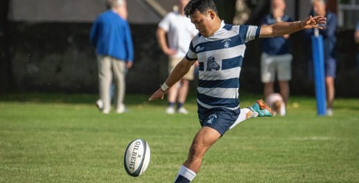 A Heriots player prepares to kick a drop-goal during a rugby match