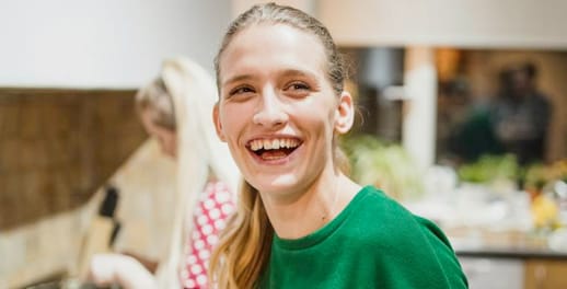 Female laughing while handing out plates of food