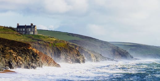 A large estate sits a top a rugged English cliff face