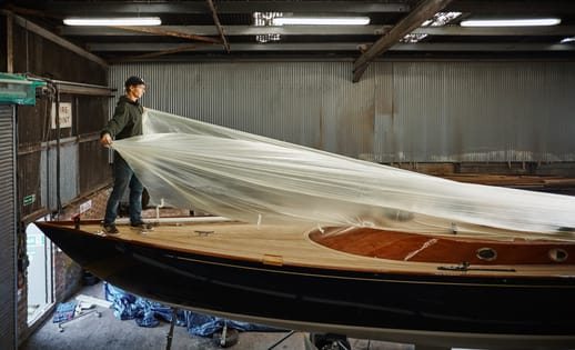 Man pulls protective cover off his vintage boat