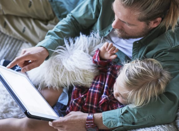 Dad and child looking at digital device