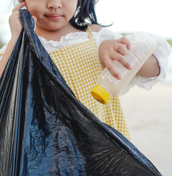 little girl engaging in beach litter clean-up