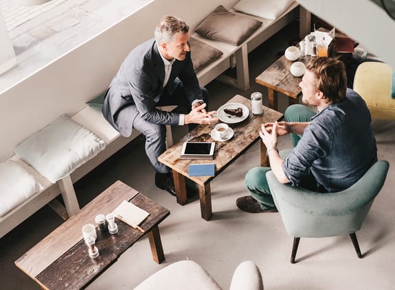 Aerial photo of two businessmen chatting over coffee