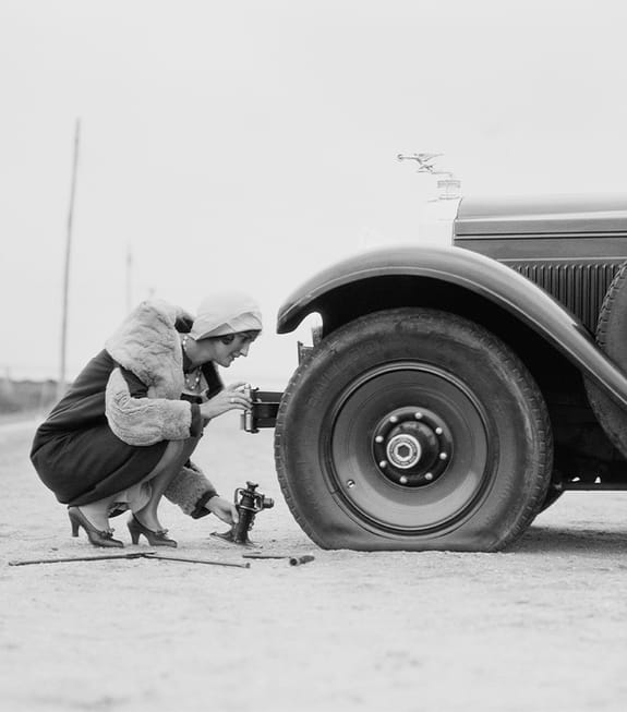 Female changing a flat tyre