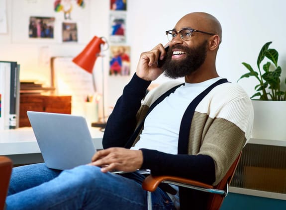 man on his laptop and cell phone