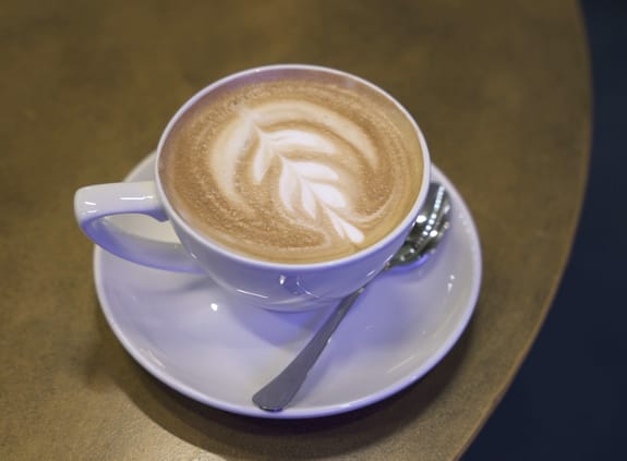 Looking down at coffee cup sitting on wooden table