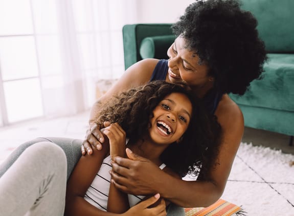 Mother and daughter laughing on the floor