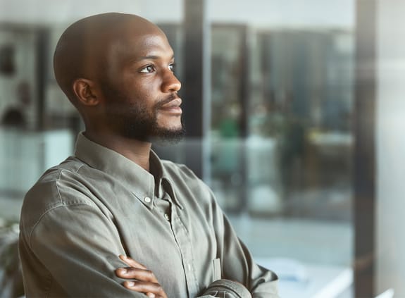 Shot of a businessman looking thoughtfully out of an office window